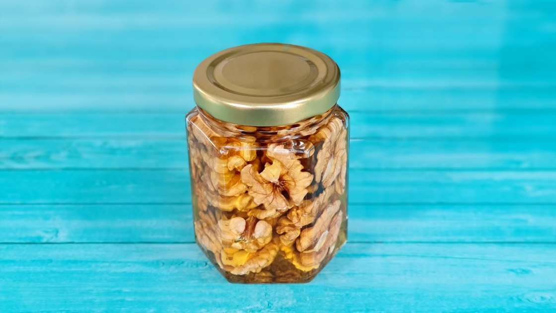 Walnut kernels with honey in a jar, photo 1