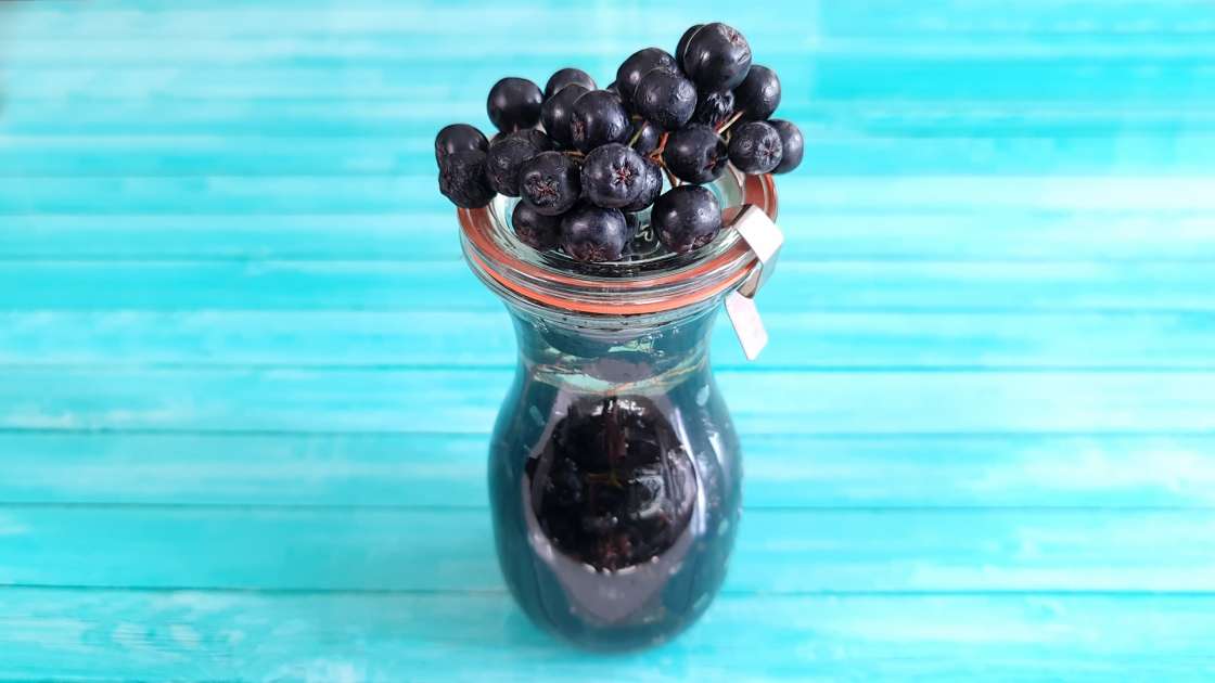 Aronia bunches with honey in a jar, photo 1